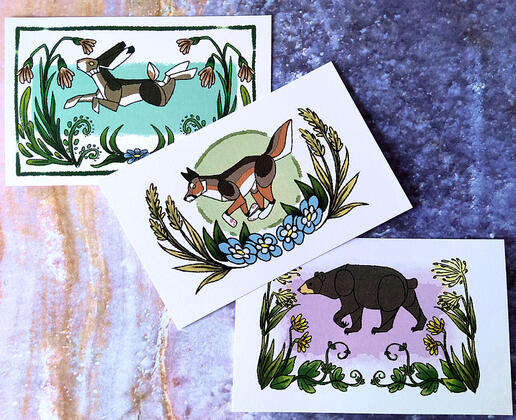 Flora & Fauna Prints, a series of postcard prints showing a jackrabbit, a coyote, and a black bear with floral borders. Flora & Fauna Prints, a series of postcard prints showing a jackrabbit, a coyote, and a black bear with floral borders.